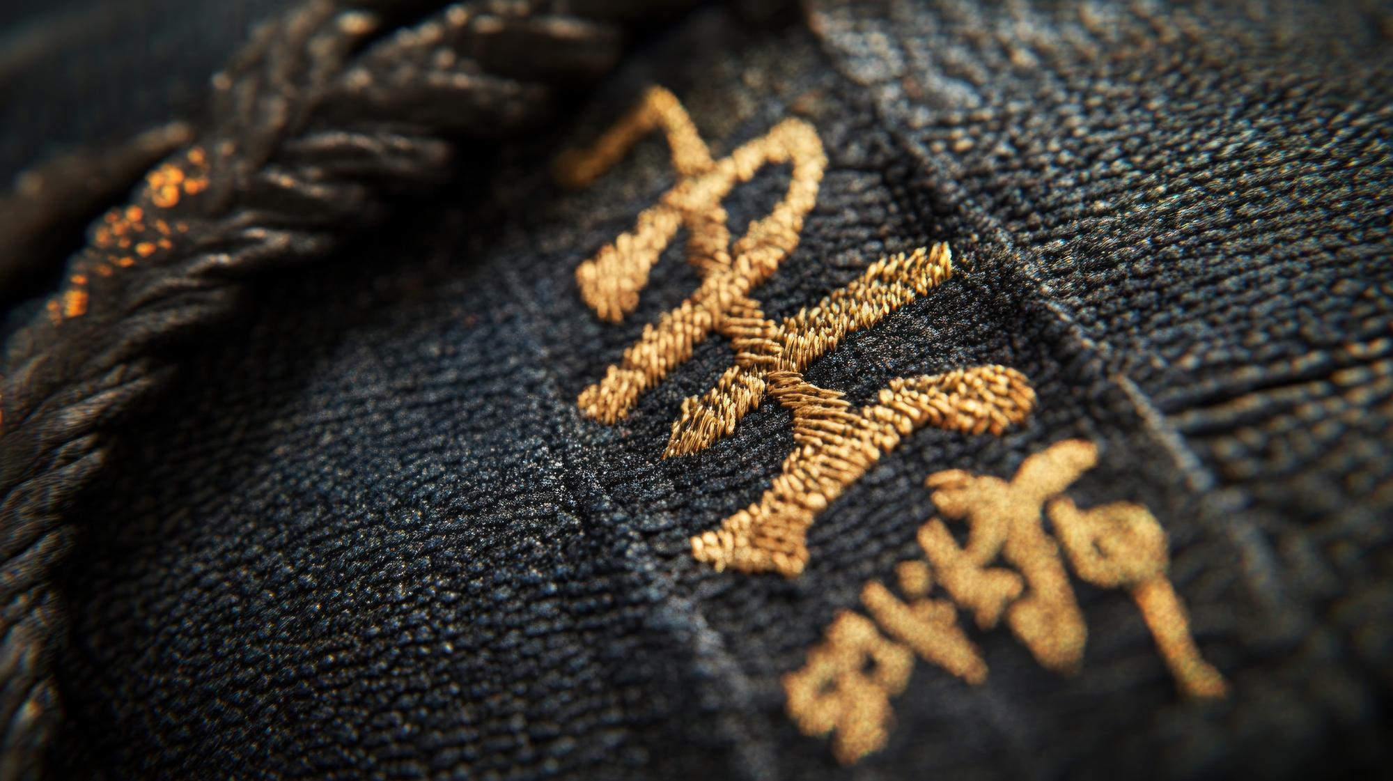Close-up of gold-thread embroidery on dark fabric